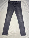 A pair of dark gray slim-fit jeans laid flat on a white fabric background.