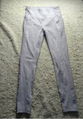 A pair of light gray high-waisted leggings laid flat on a textured beige carpet. The photo is taken from a top-down angle with a camera watermark at the bottom showing 'POVA 6 Neo' and camera settings.