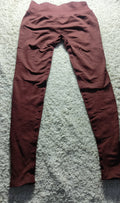 A pair of high-waisted, wide-leg leggings in a dusty rose or mauve color, laid flat on a textured gray carpet.