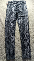 Black and white snakeskin print leggings laid flat on a beige carpet.