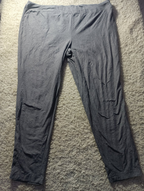 A pair of dark gray lounge pants or sweatpants laid flat on a textured beige carpet. The photo is taken from above with visible wrinkles in the fabric.
