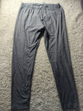 Dark gray lounge pants with an elastic waistband, laid flat on a textured gray carpet.