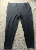 Black pants laid flat on a textured beige carpet, photographed from above with a camera metadata watermark at the bottom.