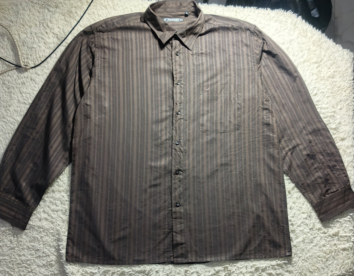 A long-sleeve button-up shirt with vertical brown and gray stripes, laid flat on a white textured rug.