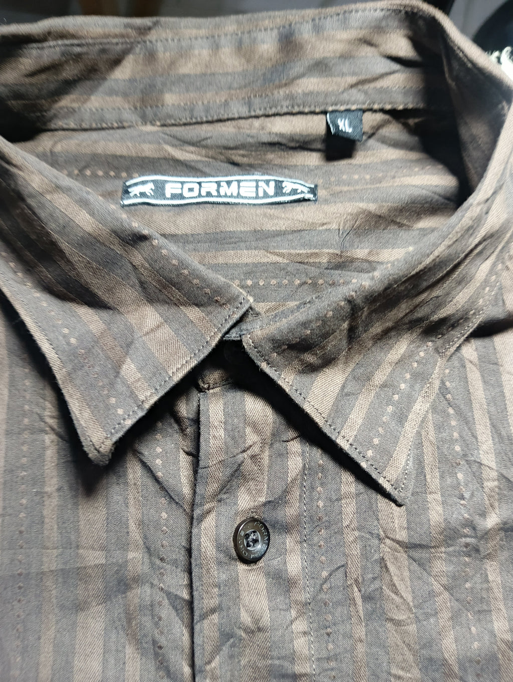 Close-up of a men's button-down shirt collar and upper chest area, showing a dark brown and gray vertically striped pattern with small white dotted details. The collar label reads FORMEN.