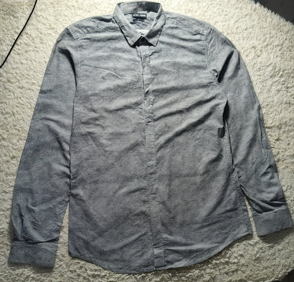 A gray long-sleeve button-down shirt with a subtle textured pattern, laid flat on a white shag rug. The brand label on the collar reads 'BONSAI'.