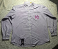 A long-sleeve button-up shirt with thin vertical purple and white stripes, featuring a pink embroidered 'NY' logo on the left chest and a black embroidered dog graphic near the bottom hem, laid flat on a white shag rug.