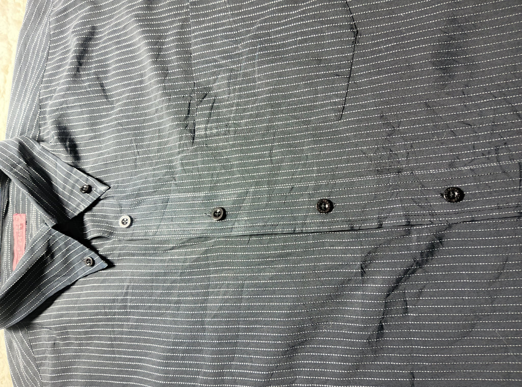 A close-up of a dark gray and white pinstriped button-down shirt laid flat, showing the collar, buttons, and textured fabric.