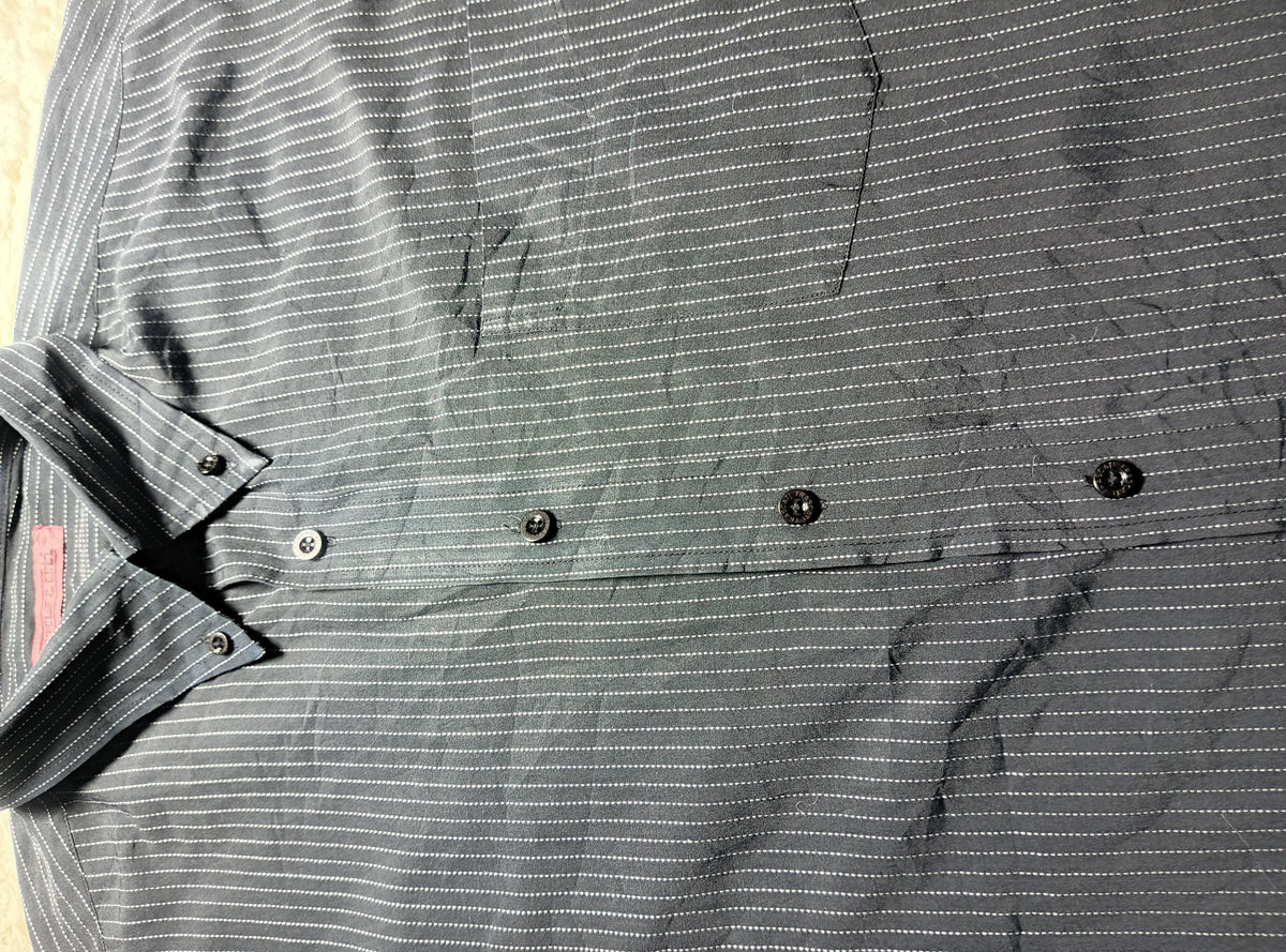 A close-up of a dark gray and white pinstriped button-down shirt laid flat, showing the collar, buttons, and textured fabric.