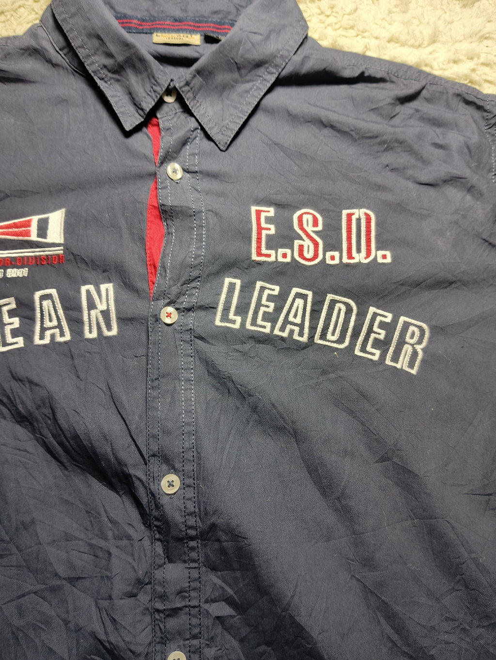A dark navy blue button-up shirt with 'E.S.