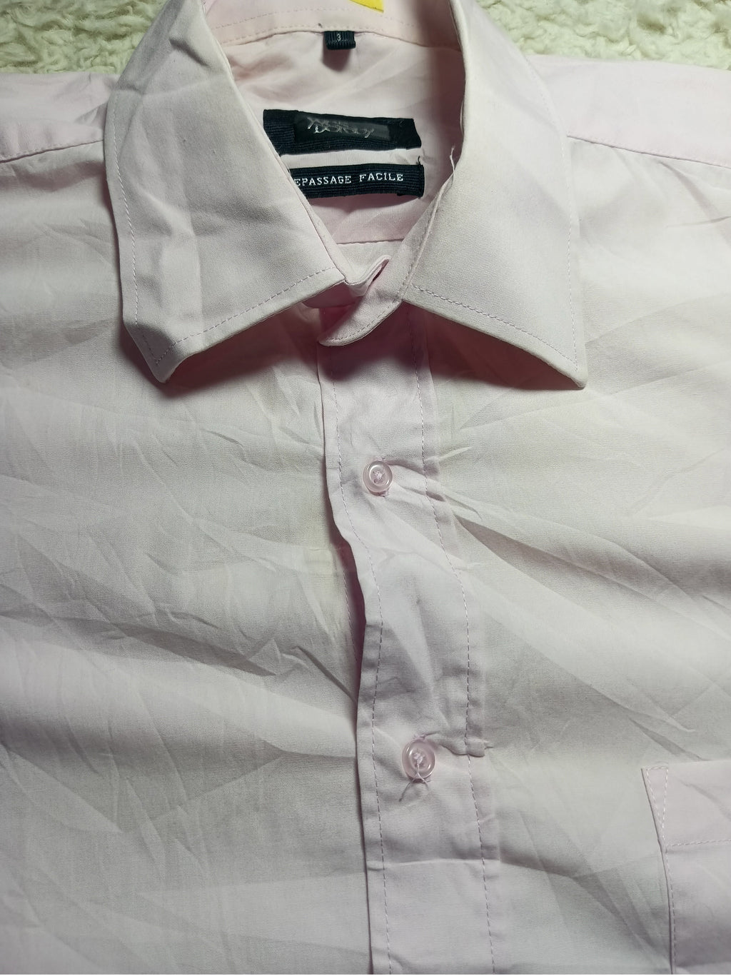 A light pink long-sleeve button-down dress shirt with a pointed collar, laid flat on a textured white surface. The brand label inside the collar reads 'Paisley Pattern'.