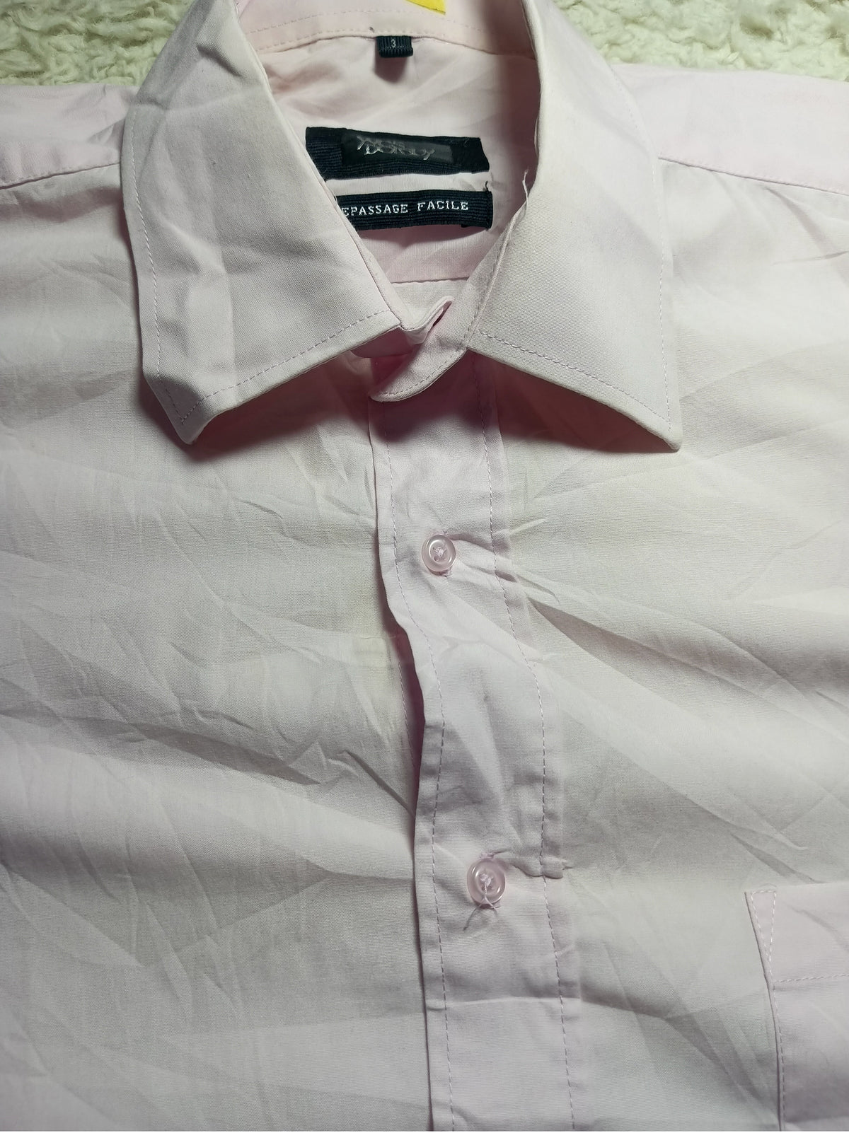 A light pink long-sleeve button-down dress shirt with a pointed collar, laid flat on a textured white surface. The brand label inside the collar reads 'Paisley Pattern'.