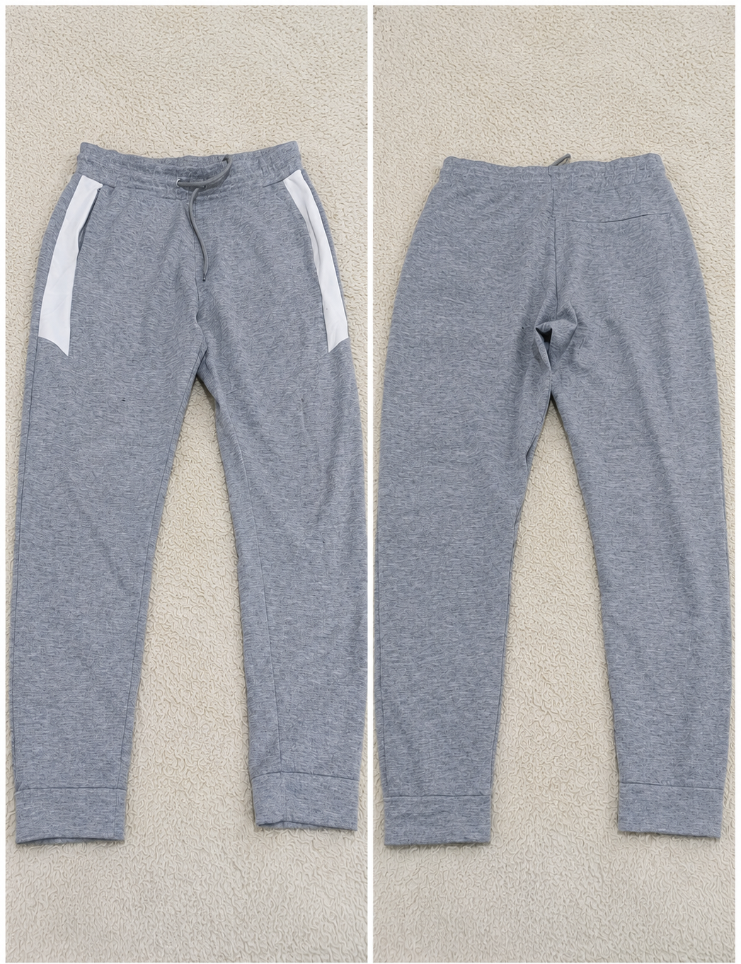 A pair of heather gray sweatpants shown from both front and back views on a textured beige background. The front view shows white side panels and a drawstring waist, while the back view shows a straight, relaxed fit.